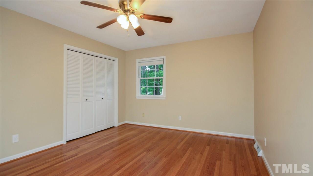 925 Pebblebrook Drive Raleigh, NC 27609 - Photo 10 of 23 an empty room with wooden floor chandelier fan and windows