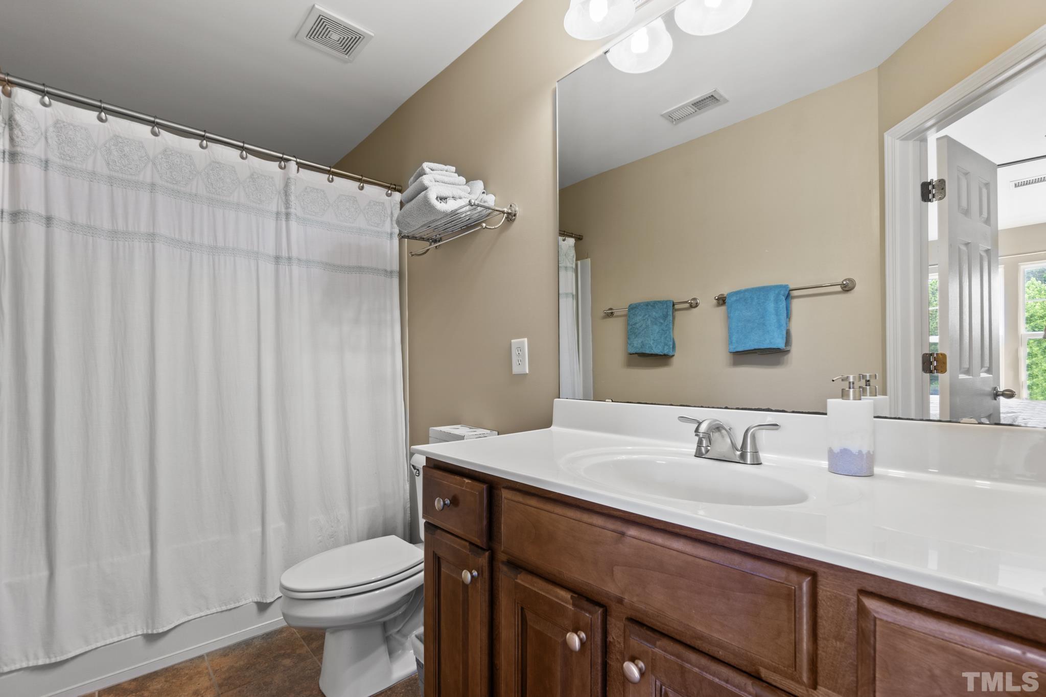 2956 Casona Way Raleigh, NC 27616 - Photo 16 of 27 a bathroom with a sink a toilet and mirror