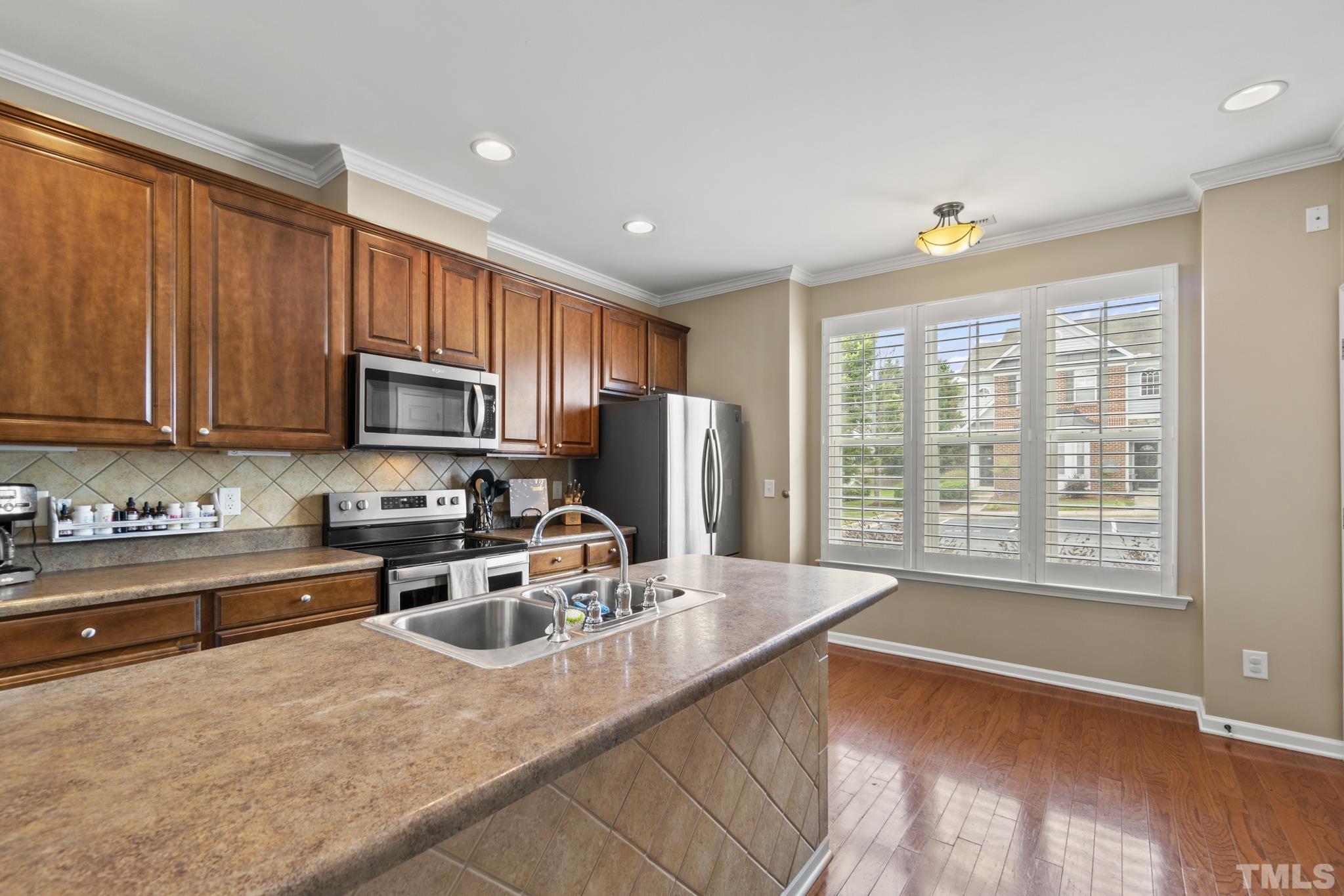 2956 Casona Way Raleigh, NC 27616 - Photo 10 of 27 a kitchen with stainless steel appliances granite countertop a sink a stove and a refrigerator