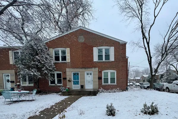 a front view of a house with a yard covered in snow