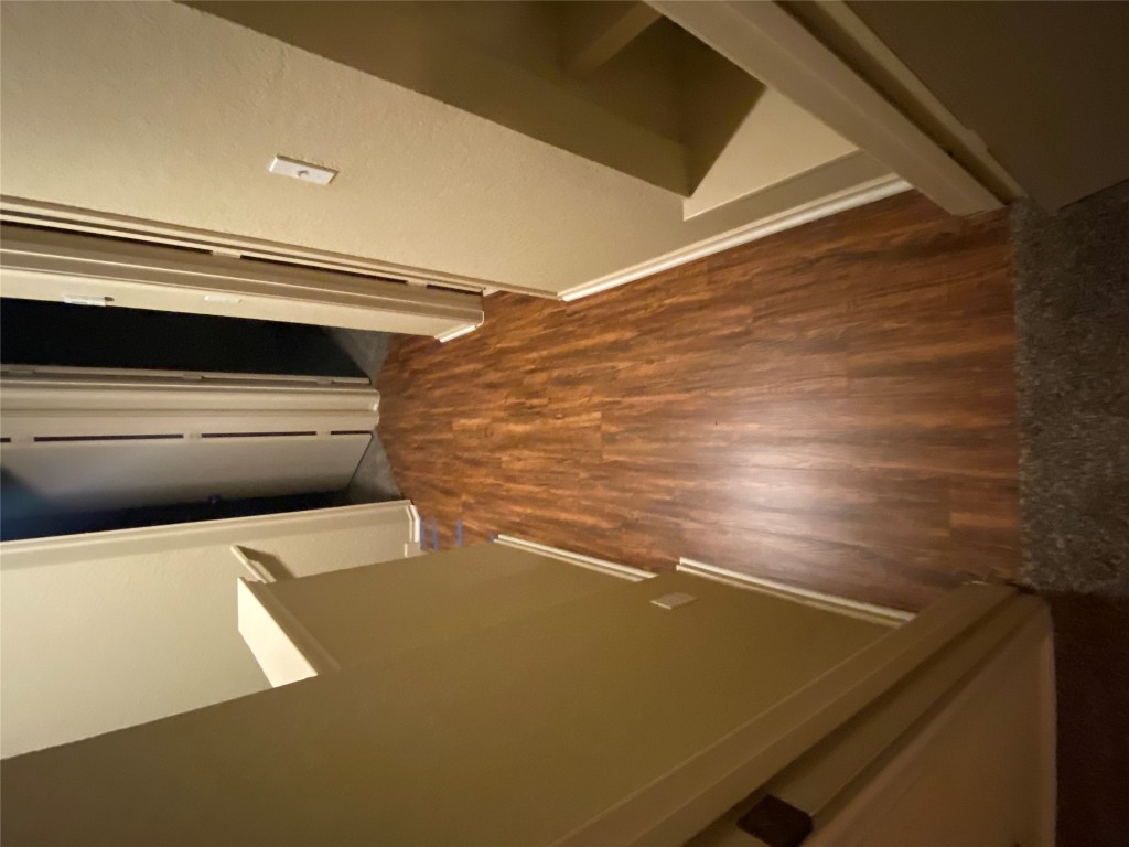 4527 Secure Lane, Unit 32 Austin, TX 78725 - Photo 8 of 9 Hall with baseboards and dark wood finished floors