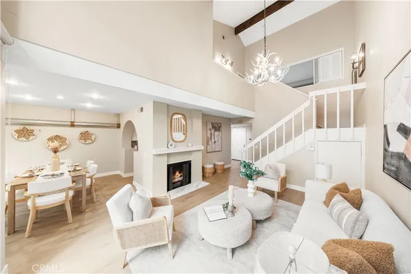 a living room with furniture a fireplace and a chandelier