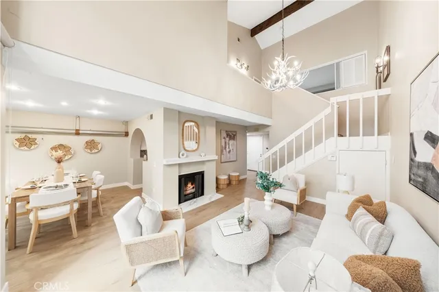 a living room with furniture a fireplace and a chandelier