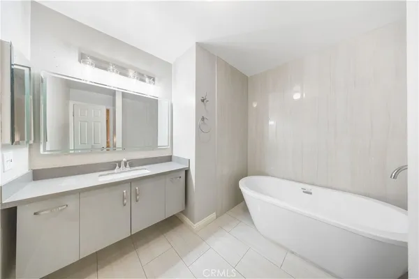 a bathroom with a bathtub sink and mirror