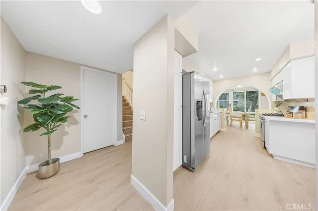 a hallway with view of wooden floor and a potted plant
