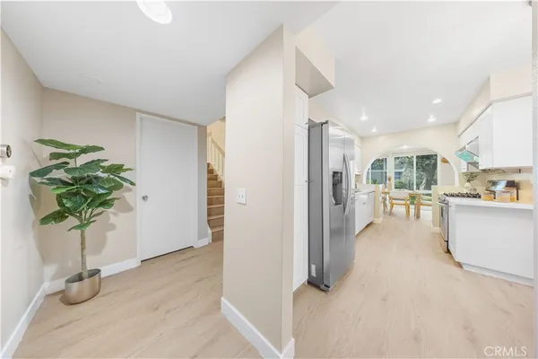 a hallway with view of wooden floor and a potted plant