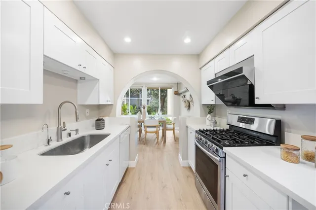 a kitchen with stainless steel appliances a sink stove and cabinets