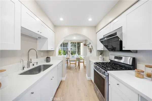 a kitchen with stainless steel appliances a sink stove and cabinets