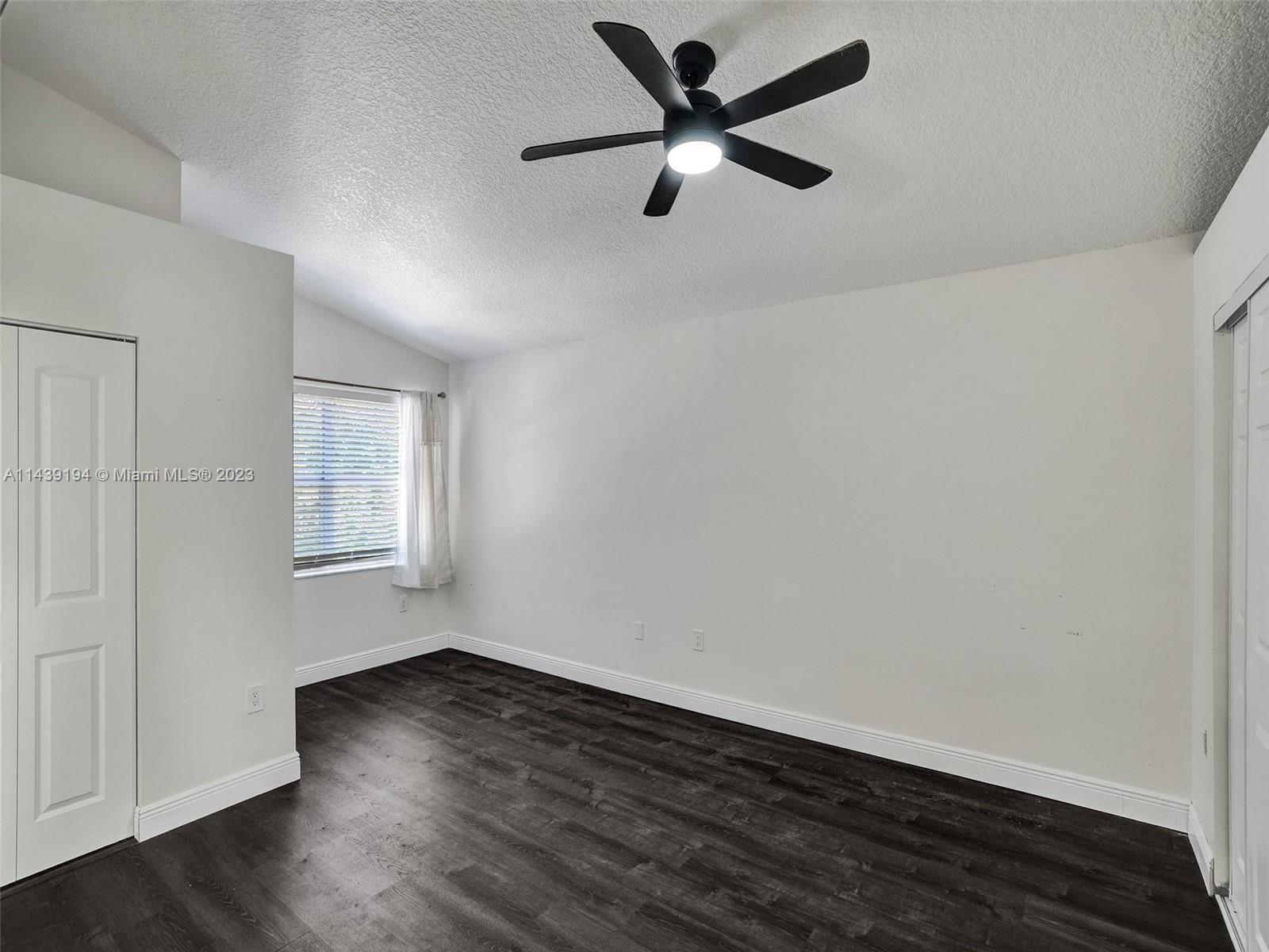 4185 Tree Top Road Cooper City, FL 33026 - Photo 16 of 36 an empty room with wooden floor and windows
