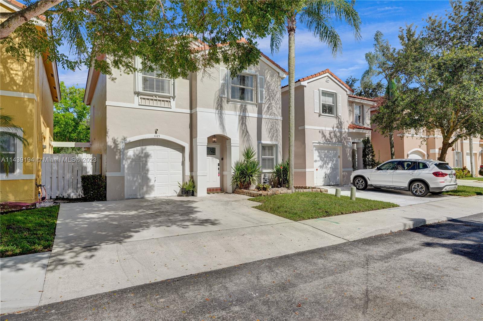 4185 Tree Top Road Cooper City, FL 33026 - Photo 2 of 36 a view of a white house with a outdoor space and a car parked in front of it