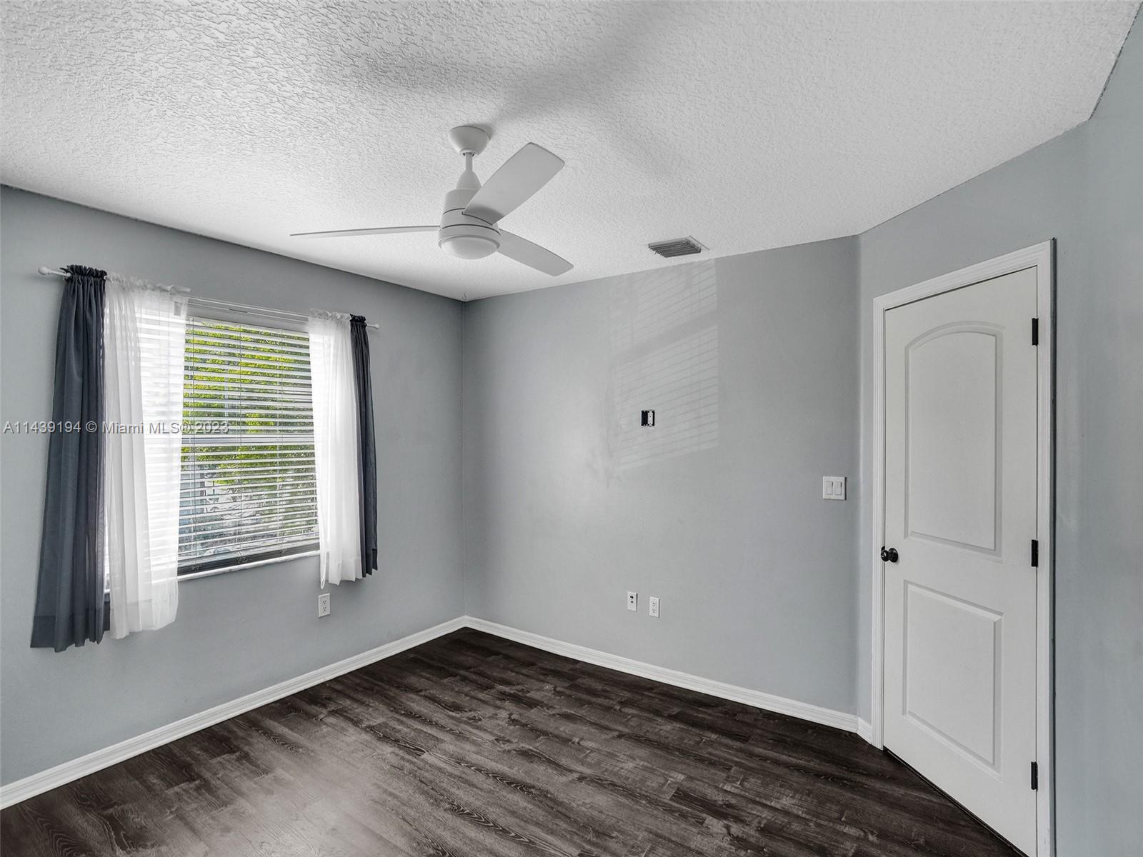 4185 Tree Top Road Cooper City, FL 33026 - Photo 22 of 36 a view of an empty room with wooden floor and a window