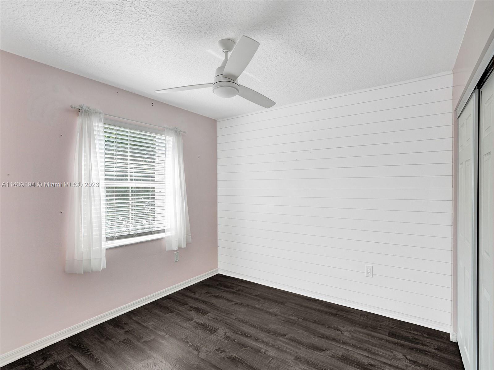 4185 Tree Top Road Cooper City, FL 33026 - Photo 25 of 36 an empty room with wooden floor and windows