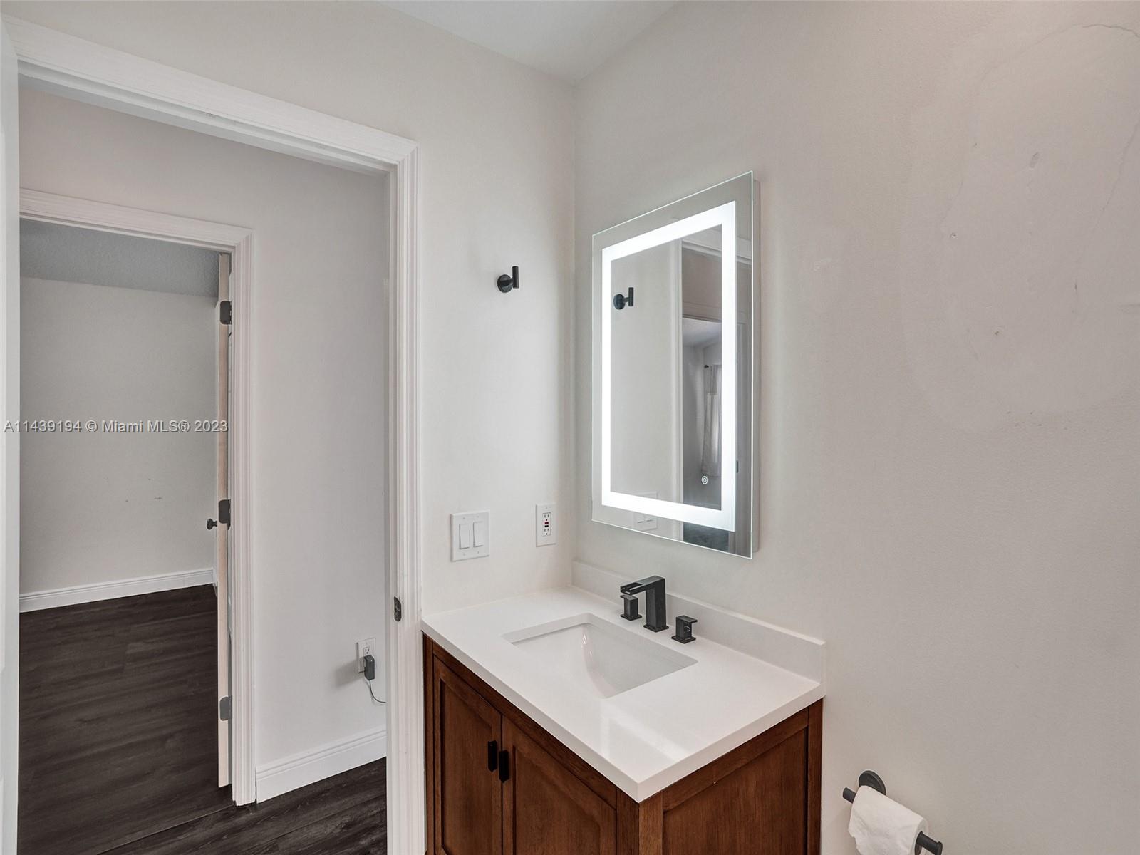 4185 Tree Top Road Cooper City, FL 33026 - Photo 27 of 36 a bathroom with a sink and a mirror