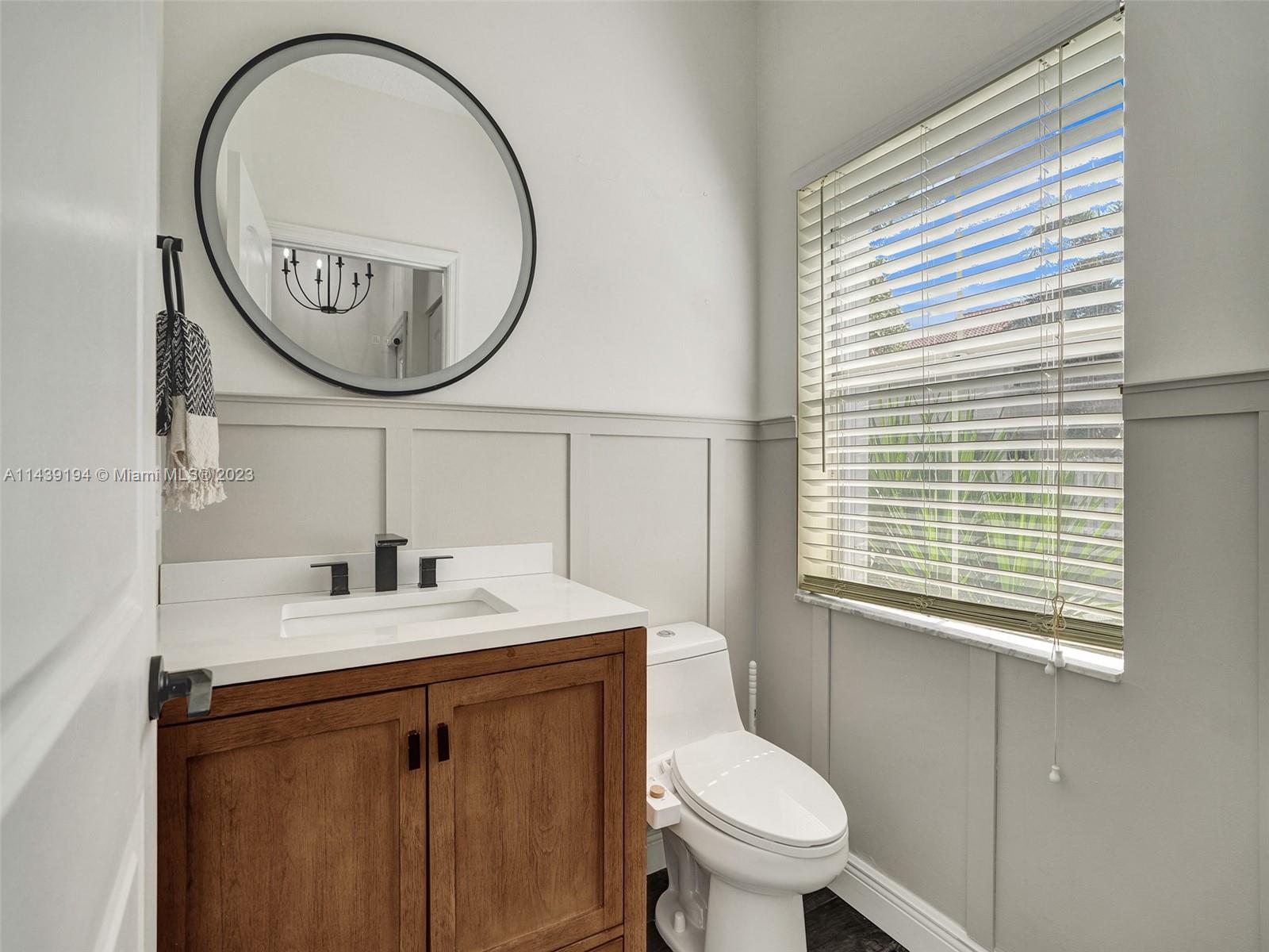 4185 Tree Top Road Cooper City, FL 33026 - Photo 4 of 36 a bathroom with a toilet a sink and a mirror