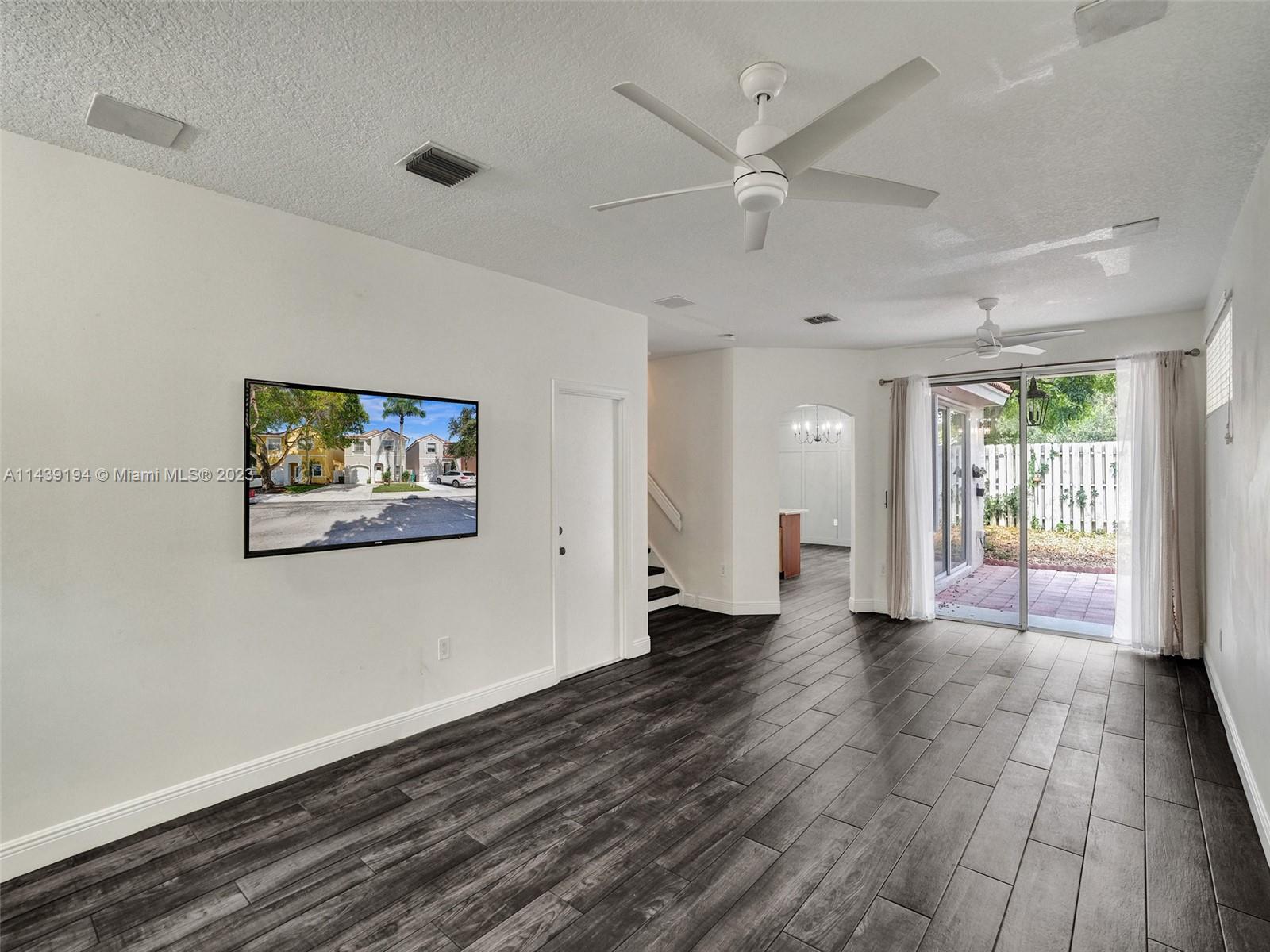 4185 Tree Top Road Cooper City, FL 33026 - Photo 6 of 36 an empty room with wooden floor and windows