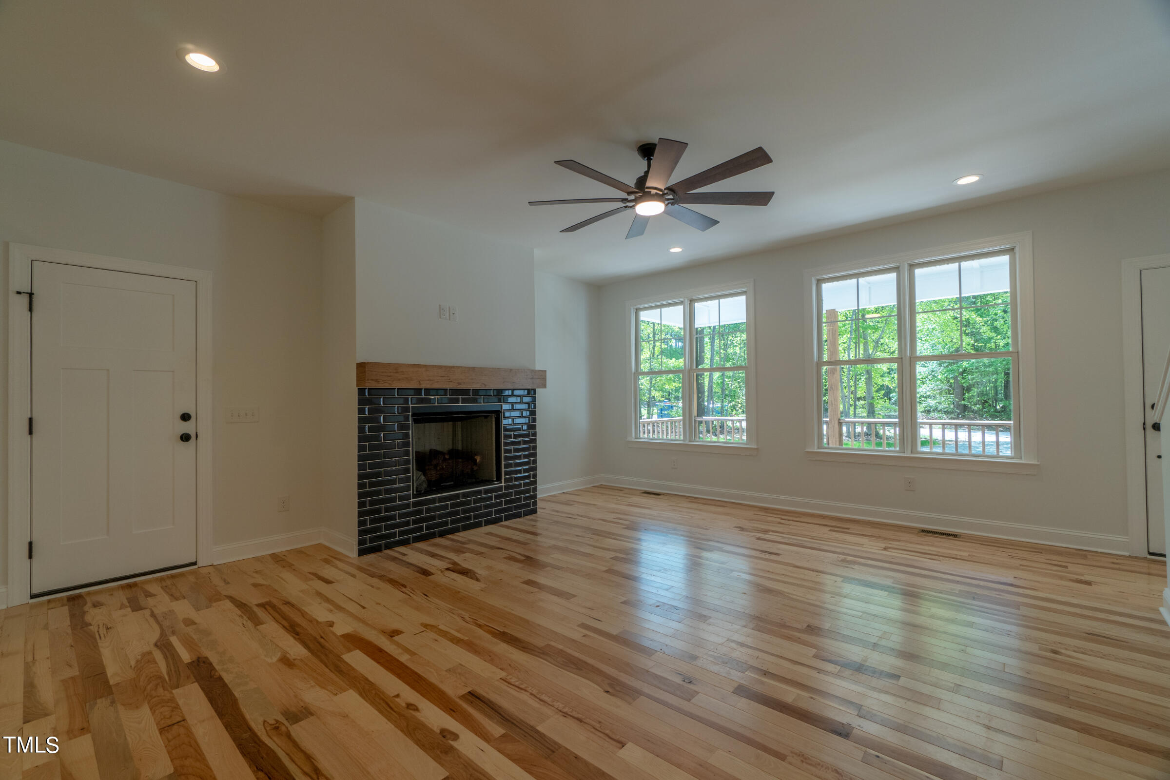 206 Goose Lane Mebane, NC 27302 - Photo 13 of 37 an empty room with windows fireplace and wooden floor