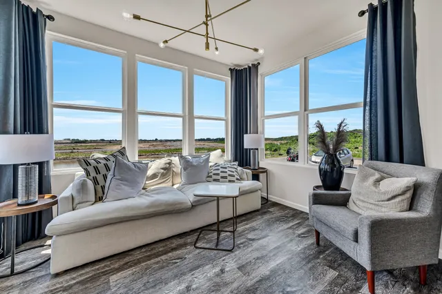 a living room with furniture and large windows
