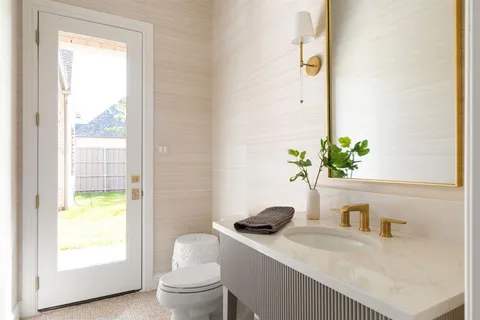 a bathroom with a granite countertop sink a toilet and a mirror