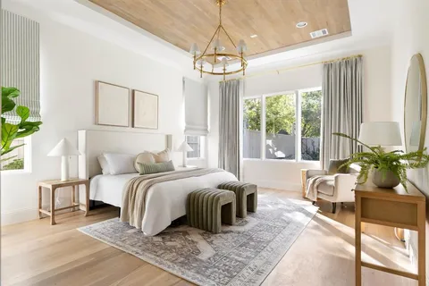 a bedroom with a bed a chandelier and a couch