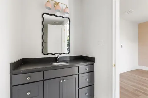 a bathroom with a granite countertop sink and a mirror
