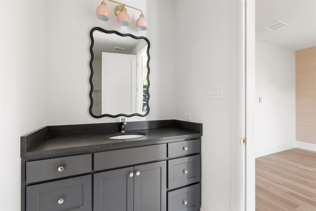 6541 Oriole Drive Dallas, TX 75209 - Photo 23 of 31 a bathroom with a granite countertop sink and a mirror