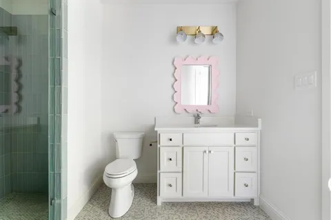 a bathroom with a toilet sink vanity and mirror