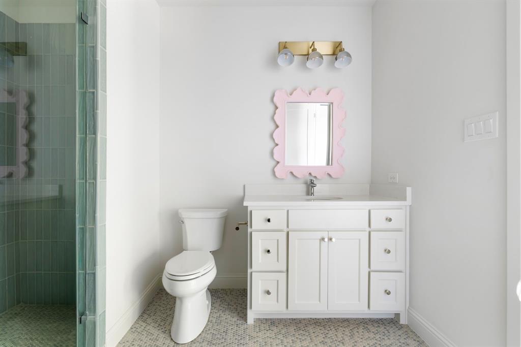 6541 Oriole Drive Dallas, TX 75209 - Photo 25 of 31 a bathroom with a toilet sink vanity and mirror
