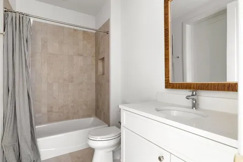 a bathroom with a sink a toilet a mirror and a shower