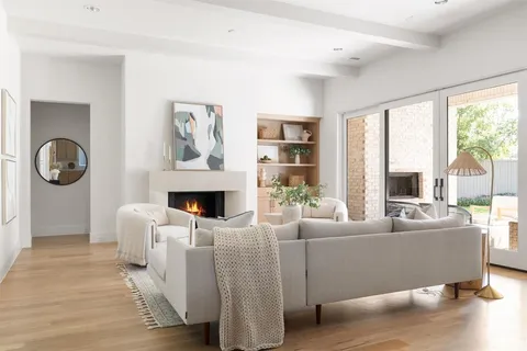 a living room with furniture a fireplace and a large window