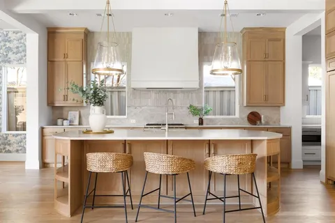 a kitchen with stainless steel appliances a table chairs refrigerator and sink