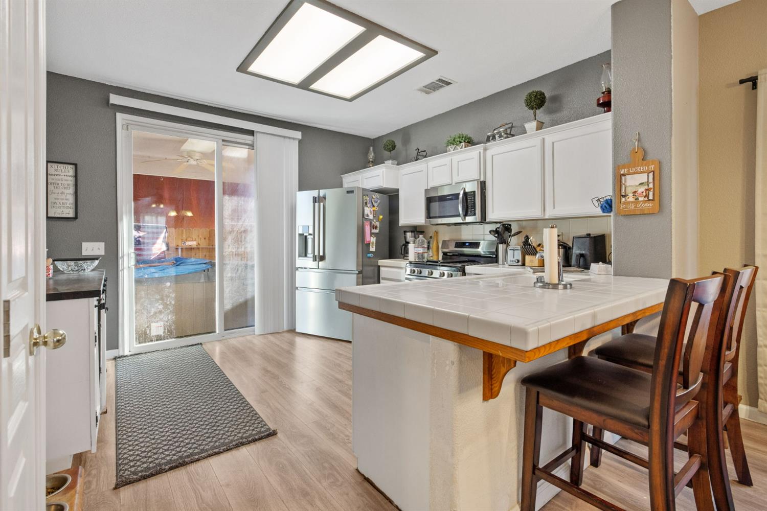 1963 West Merritt Street Hanford, CA 93230 - Photo 12 of 32 a kitchen with stainless steel appliances granite countertop a stove a refrigerator a sink and a dining table with wooden floor