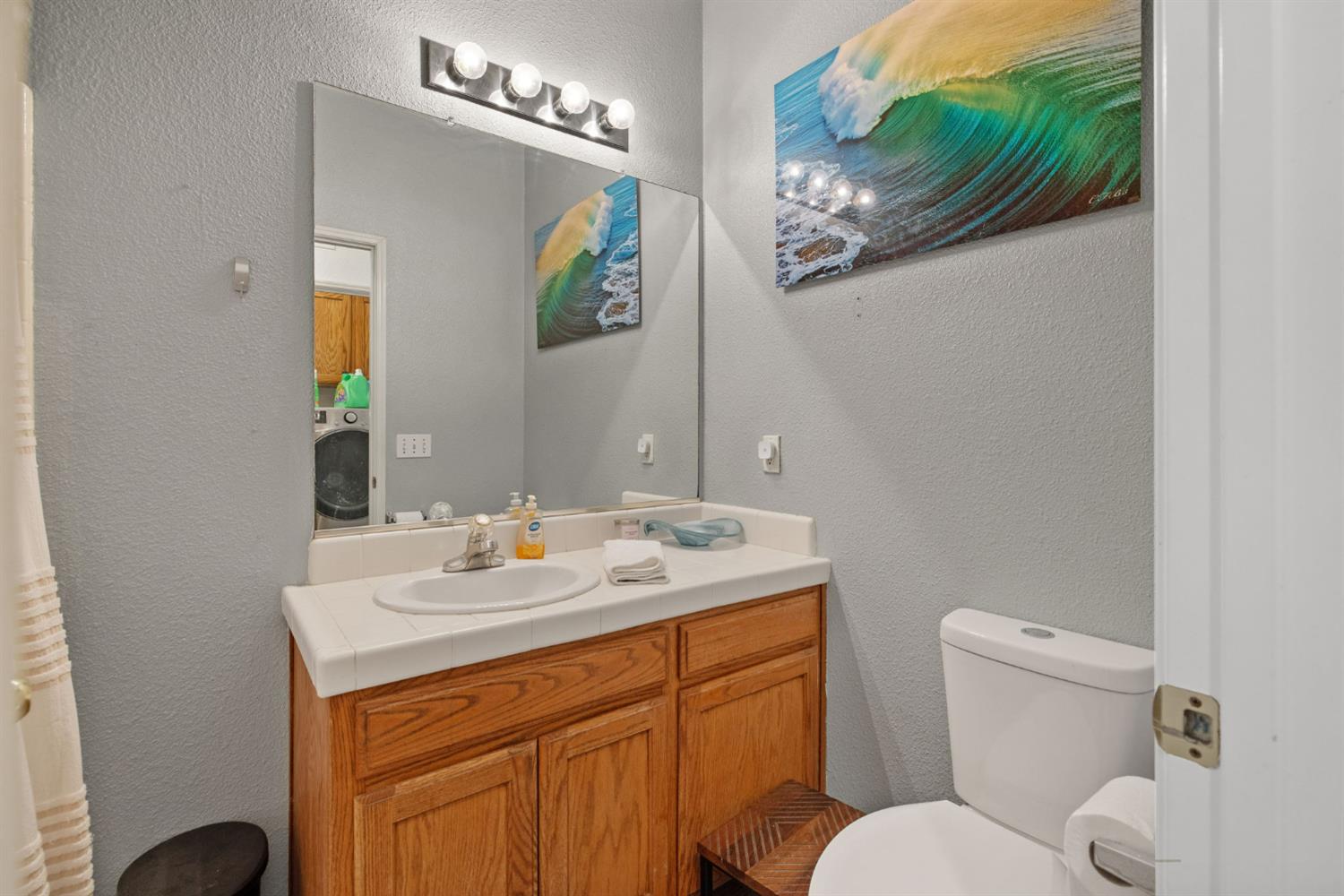 1963 West Merritt Street Hanford, CA 93230 - Photo 25 of 32 a bathroom with a toilet a sink and mirror