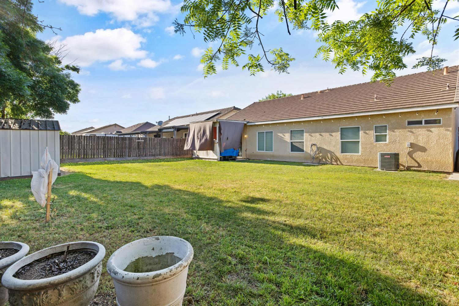 1963 West Merritt Street Hanford, CA 93230 - Photo 29 of 32 a view of a white house with a swimming pool and a yard