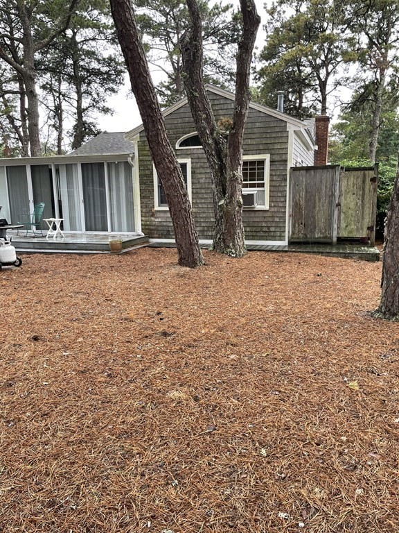 20 Lawrence Road Dennis Port, MA 02639 - Photo 24 of 29 a backyard of a house with large trees and brick walls