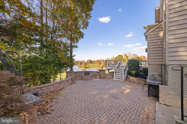 a kitchen with stainless steel appliances granite countertop a refrigerator a sink dishwasher a stove and a dining table with wooden floor