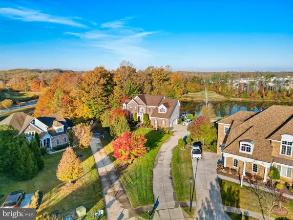 a view of a big house with a big yard and large trees