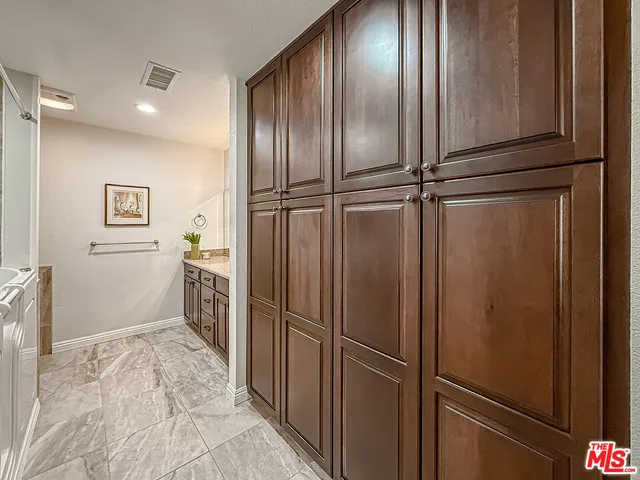 a bedroom with a bed and dresser with chair