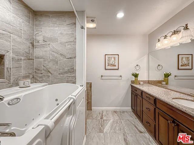 a bathroom with a granite countertop sink a toilet and shower