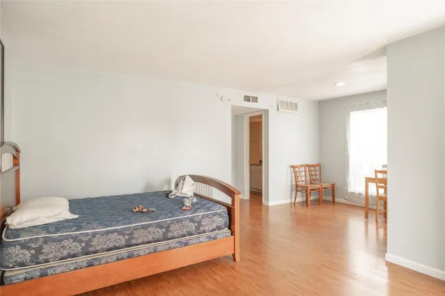 a bedroom with a bed and wooden floor