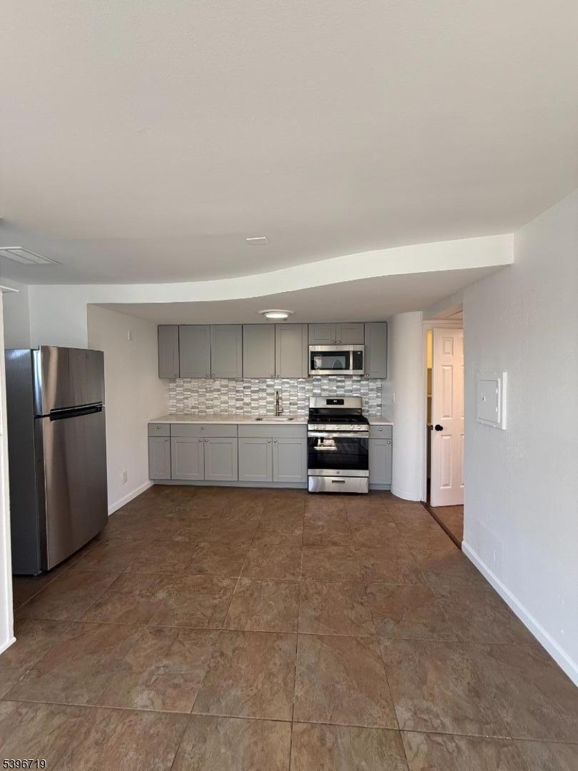 201 4th Street Clifton, NJ 07011 - Photo 4 of 8 a view of a kitchen with a sink stove and cabinets