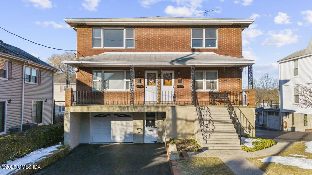 a view of a white house with large windows and a table and chairs