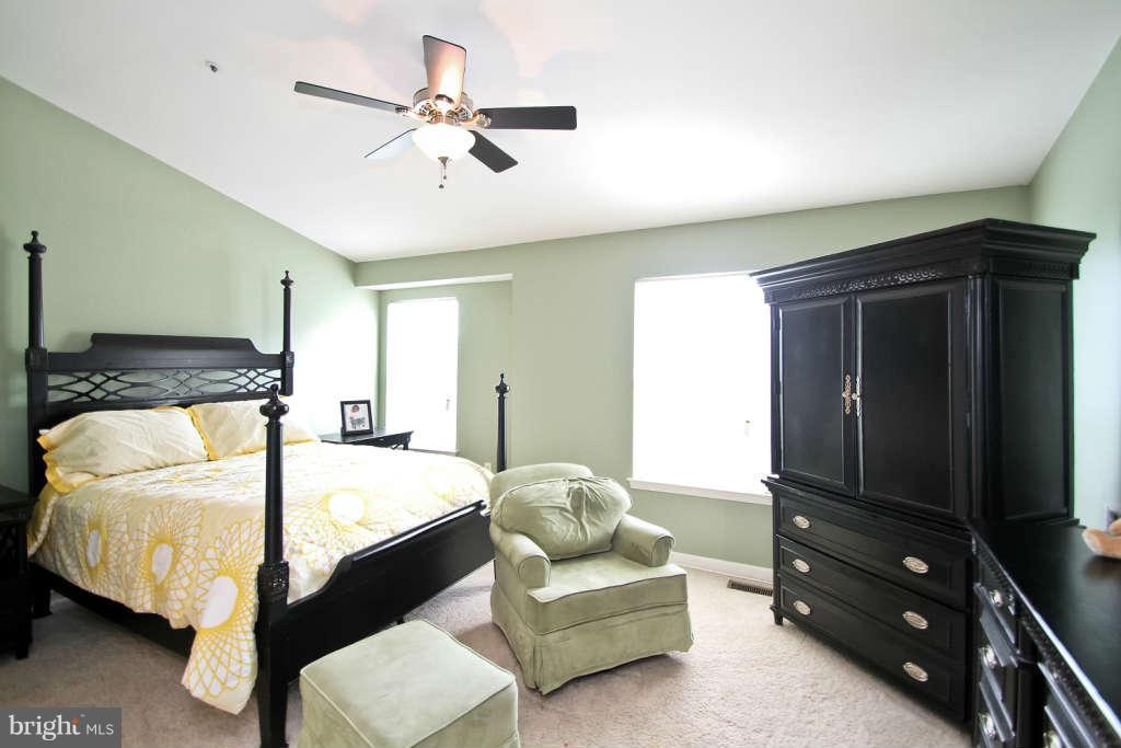 4739 Ridgeline Terrace, Unit 301 Bowie, MD 20720 - Photo 12 of 25 a bedroom with a bed and a flat tv screen