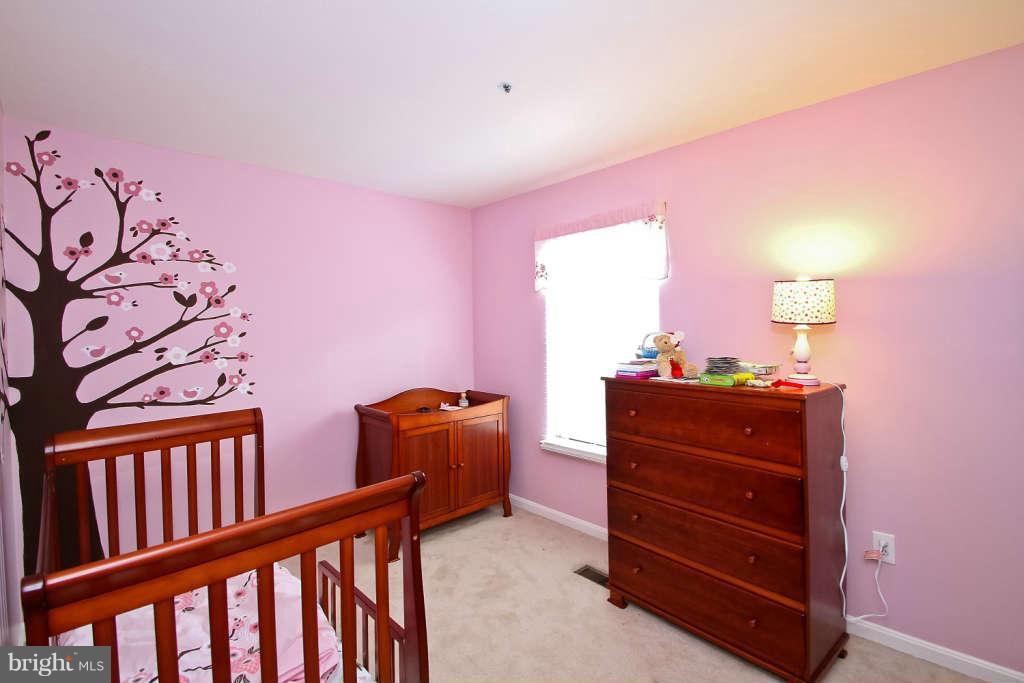 4739 Ridgeline Terrace, Unit 301 Bowie, MD 20720 - Photo 19 of 25 a bed room with a bed and a dresser