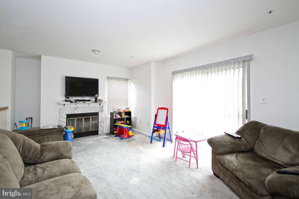 4739 Ridgeline Terrace, Unit 301 Bowie, MD 20720 - Photo 3 of 25 a living room with furniture and a flat screen tv
