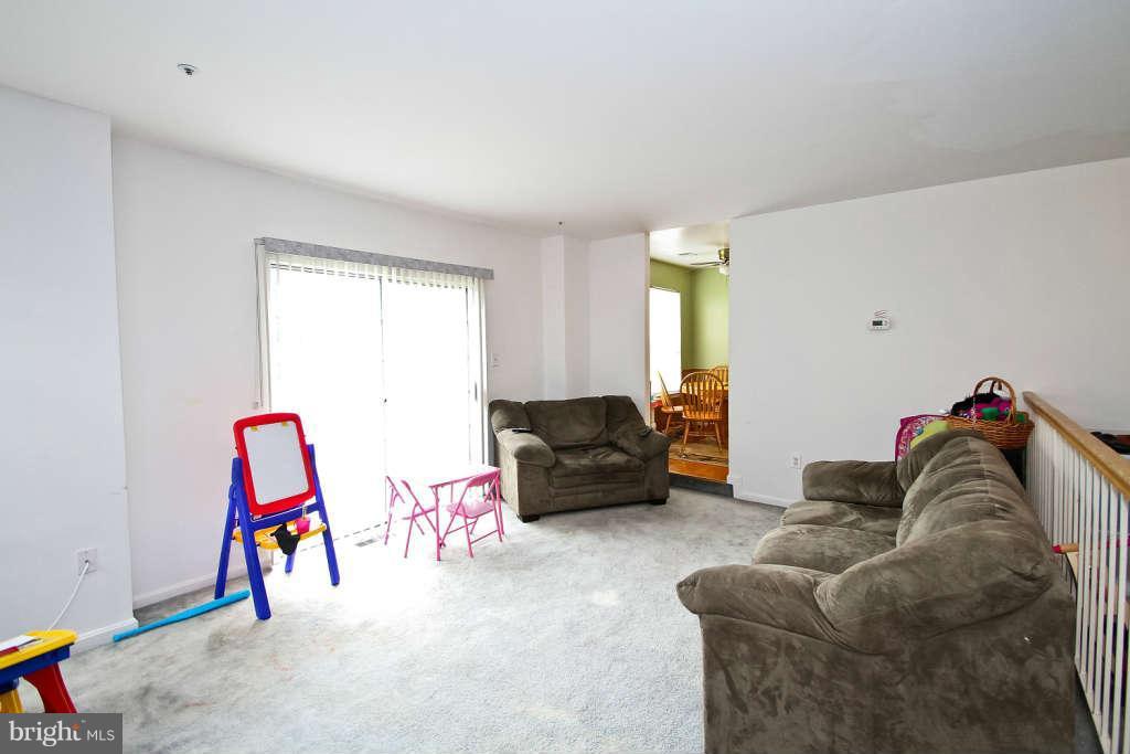 4739 Ridgeline Terrace, Unit 301 Bowie, MD 20720 - Photo 5 of 25 a living room with furniture and gym equipment