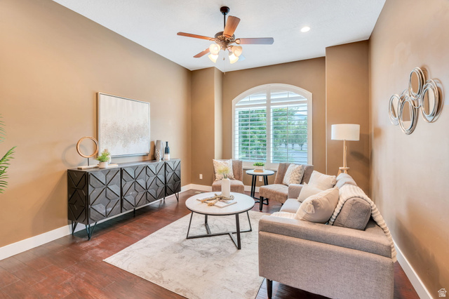1355 West 1000 South Mapleton, UT 84664 - Photo 20 of 68 Living area featuring wood-finish flooring, an arched window with louvered shutters, a ceiling fan with integrated lighting, and crown molding