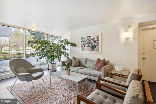 a living room with furniture and a large window with garden view