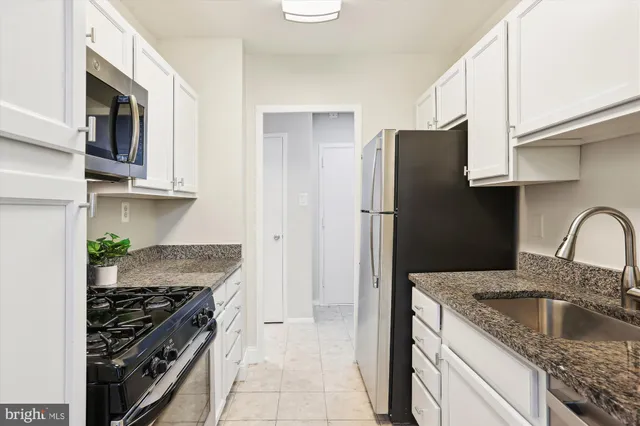 a kitchen with stainless steel appliances granite countertop a refrigerator stove and sink