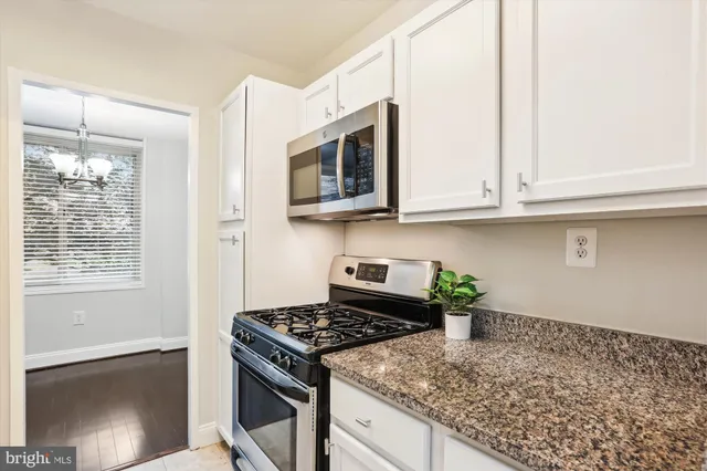 a kitchen with stainless steel appliances granite countertop a stove a microwave and a sink