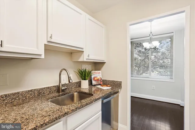 a kitchen with a granite countertop sink and cabinets